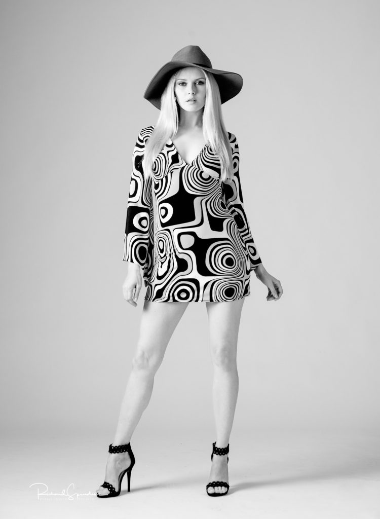 fashion photographer - fashion photography - monochrome vintage fashion shoot with model wear a sixty style psychedelic designed dress hat and black shoes