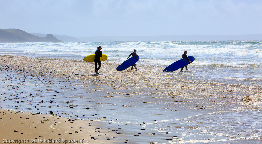 Travel Photography - travel Photograher - colour image of three surfers heading towards the sea carrying their boards