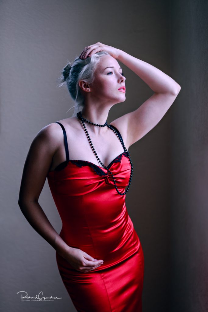 fashion photographer - fashion photography - colour image from a studio fashion shoot subject is wearing a red ball dress, shot using natural light