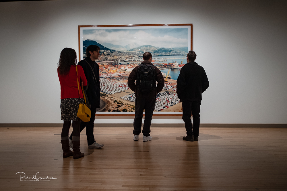 travel photography - travel photograher - colour image from a visit to the hayward gallery focusing on the visitors viewing the Gursky images in this the four people adopt different viewing looks