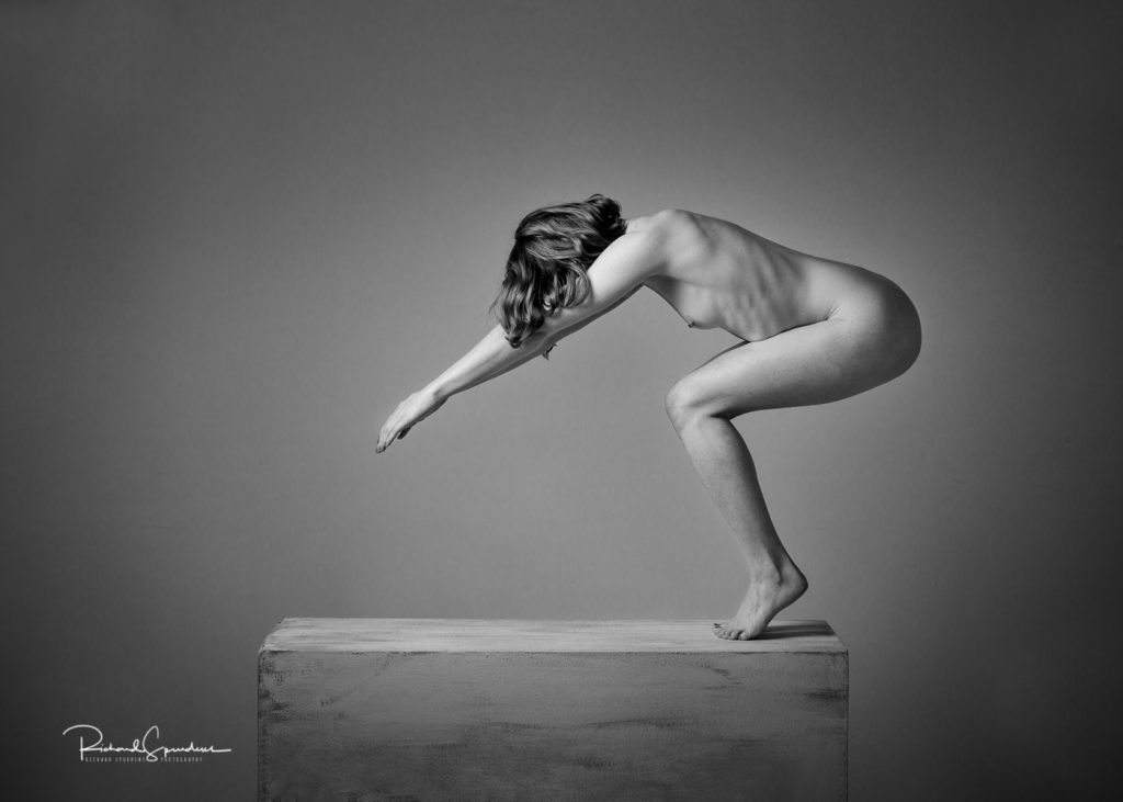 Fine Art Nude Photography - Fine Art Nude Photographer - monochrome image showing a stong artistic nude figure shape standing on a plinth