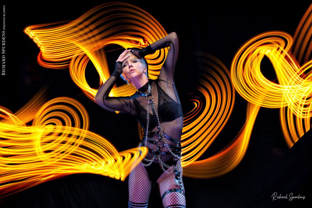 Light painting Photography - Fashion Photographer - colour image using a yellow light painting wand creating yellow swirls around the model