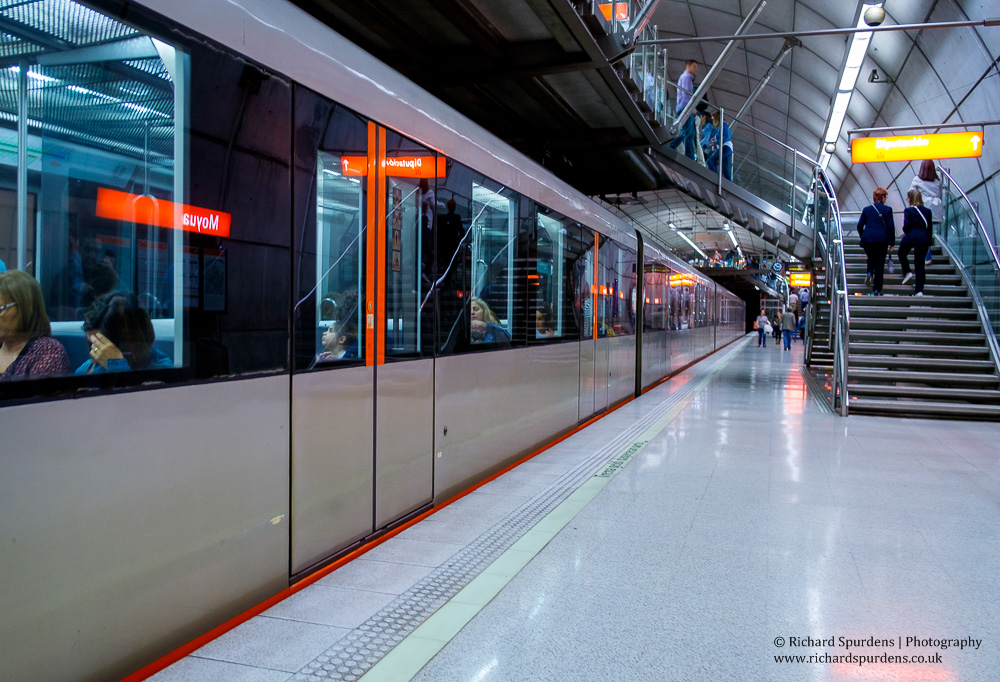 travel photography - travel photographer - colour image showing the station platform at moyua station with a train in the platform with the station name reflecting in the carrage windows