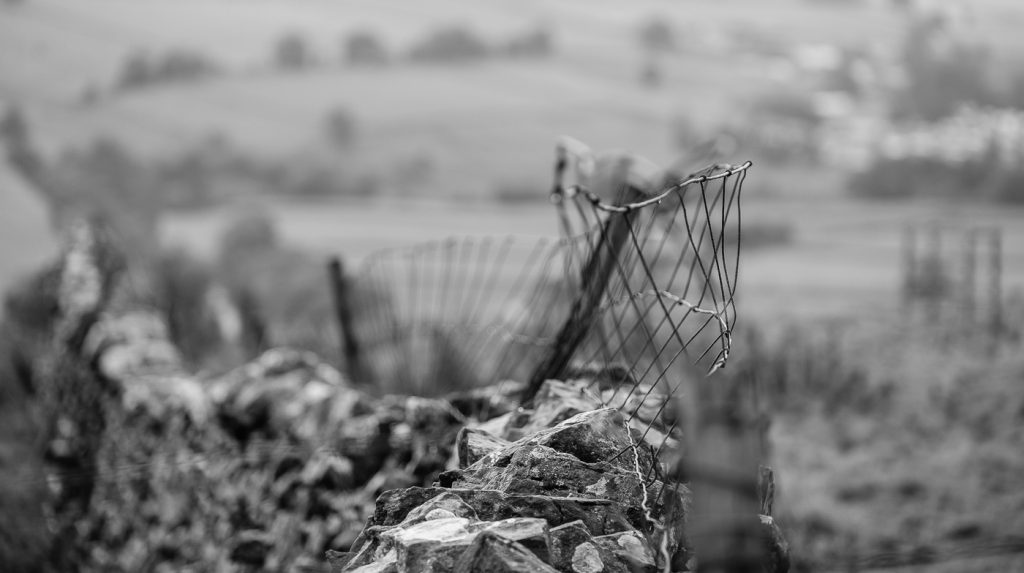 Landscape Photography - Landscape Photographer - monochrome image of wire fence on top of a dry stone wall, using a shallow depth of field