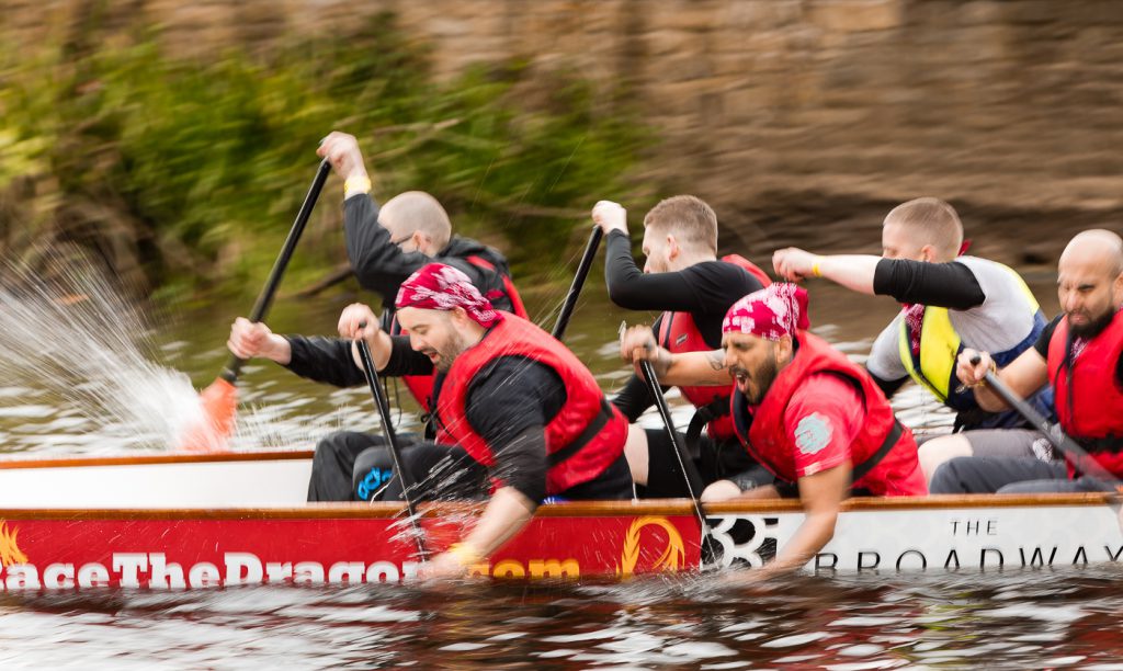 sport photography - sport photographer -colour image of dragon boat racing on the river aire at roberts park saltaire, a slow shutter speed was used together with panning to give a feel of the speed