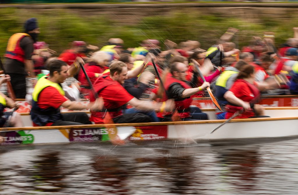 sport photography - sport photographer -colour image of dragon boat racing on the river aire at roberts park saltaire, a slow shutter speed was used together with panning to give a feel of the speed