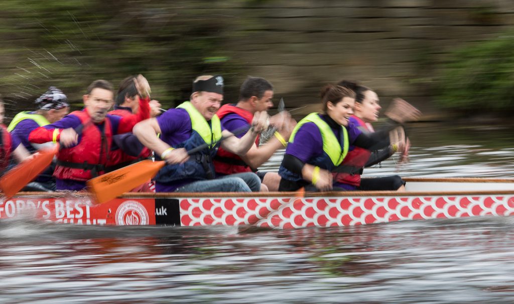 sport photography - sport photographer -colour image of dragon boat racing on the river aire at roberts park saltaire, a slow shutter speed was used together with panning to give a feel of the speed