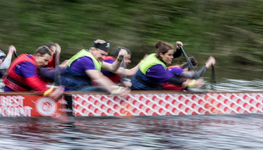 sport photography - sport photographer -colour image of dragon boat racing on the river aire at roberts park saltaire, a slow shutter speed was used together with panning to give a feel of the speed