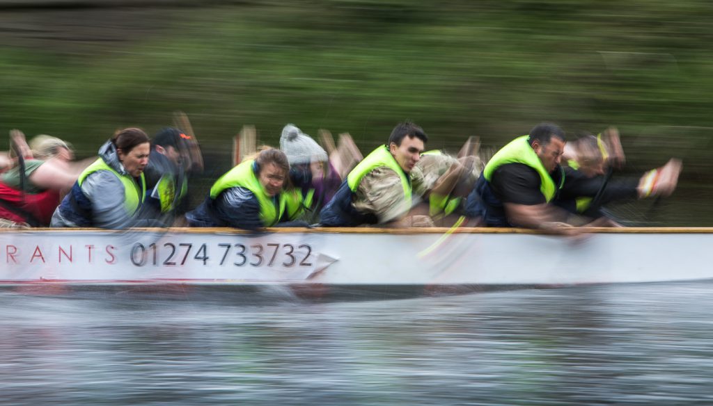 sport photography - sport photographer -colour image of dragon boat racing on the river aire at roberts park saltaire, slow shutter speed was used with panning of the camera to give an abstract effect and feel of speed