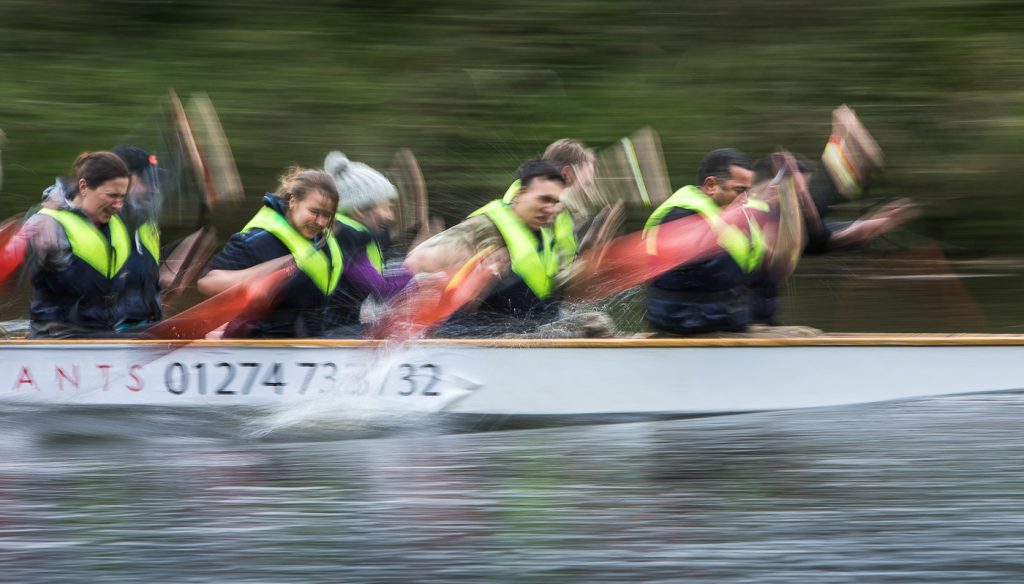 sport photography - sport photographer -colour image of dragon boat racing on the river aire at roberts park saltaire, slow shutter speed was used to give an abstract effect and feel of speed
