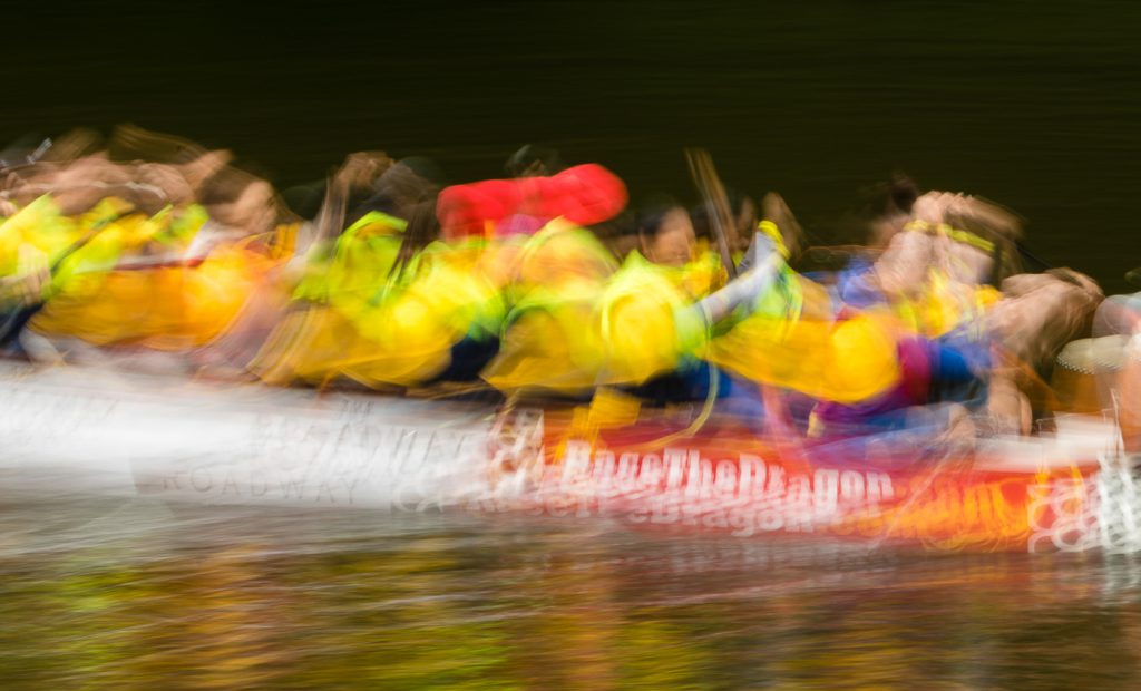 sport photography - sport photographer -colour image of dragon boat racing on the river aire at roberts park saltaire, slow shutter speed was used to give an abstract effect
