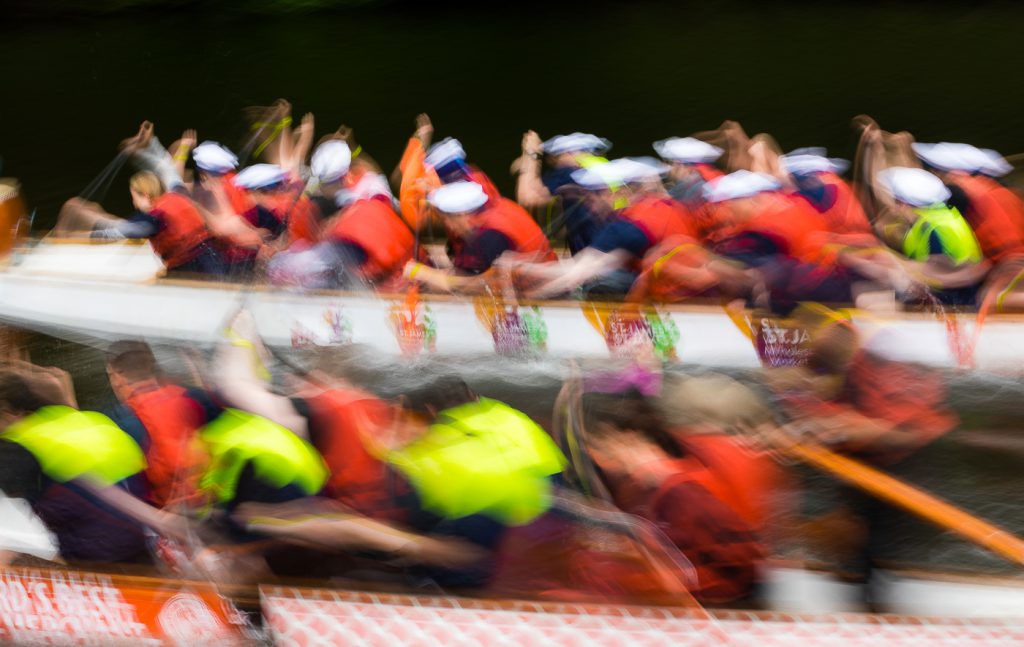 sport photography - sport photographer -colour image of dragon boat racing on the river aire at roberts park saltaire, slow shutter speed was used to give an abstract effect