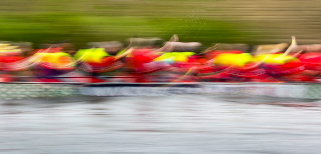 sport photography - sport photographer -colour image of dragon boat racing on the river aire at roberts park saltaire, slow shutter speed was used to give an abstract effect