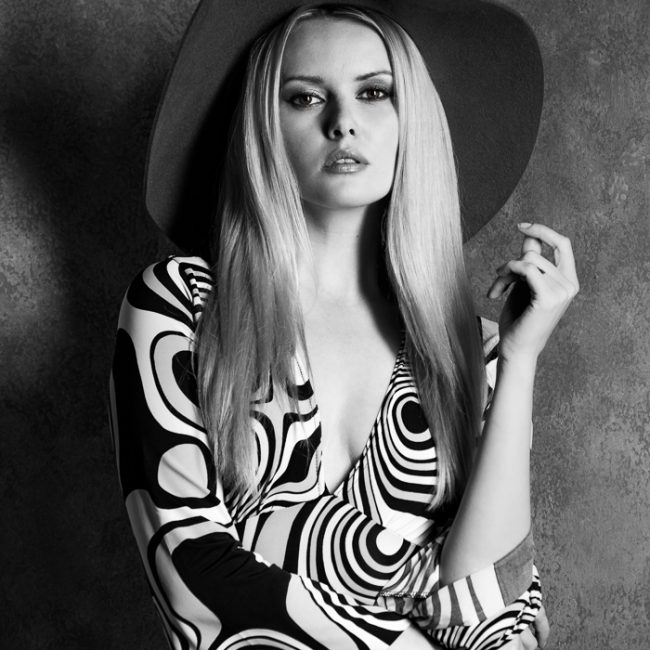 fashion photographer - fashion photography - monochrome vintage fashion shoot with model wear a sixty style psychedelic designed dress together with a wide brim hat