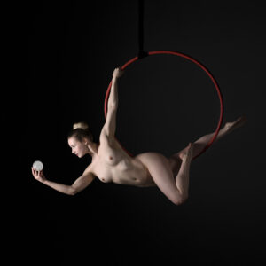 Aerial Arts photographer - Aerial hoop photographer - Aerial Arts photography - aerial artist using a red aerial hoop to hold a dynamic pose at the bottom of the hoop