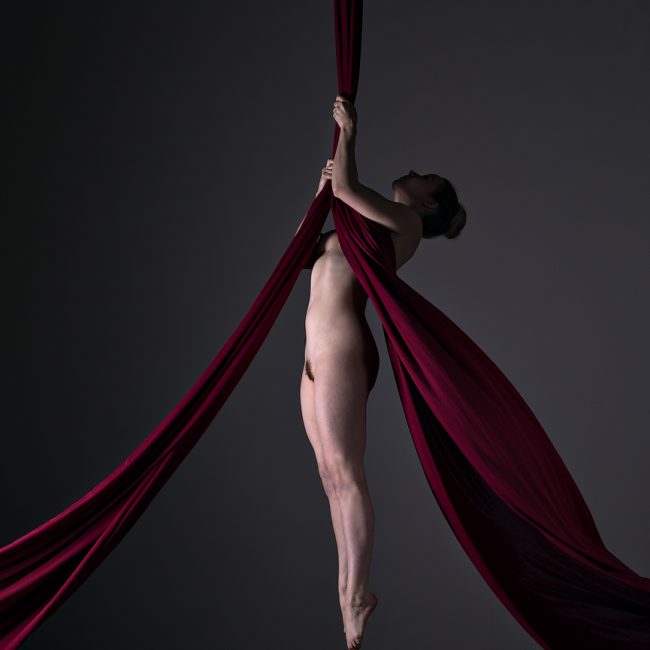 Aerial Arts photograher - Aerial silks photographer - Aerial Arts photograhy - Aerial silks photography - A fine art nude image of Em the aerialist using two silks to hand from the hands and feet pointing straight down