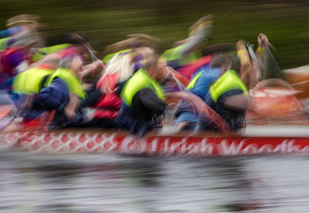 sport photography - sport photographer -colour image of dragon boat racing on the river aire at roberts park saltaire, a slow shutter speed was used to give an abstract effect and feel of speed