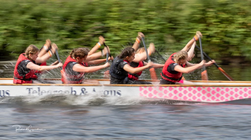 sport photography - sport photographer -colour image of dragon boat racing on the river aire at roberts park saltaire, a slow shutter speed was used together with panning to give a feel of the speed which really comes out in the shot