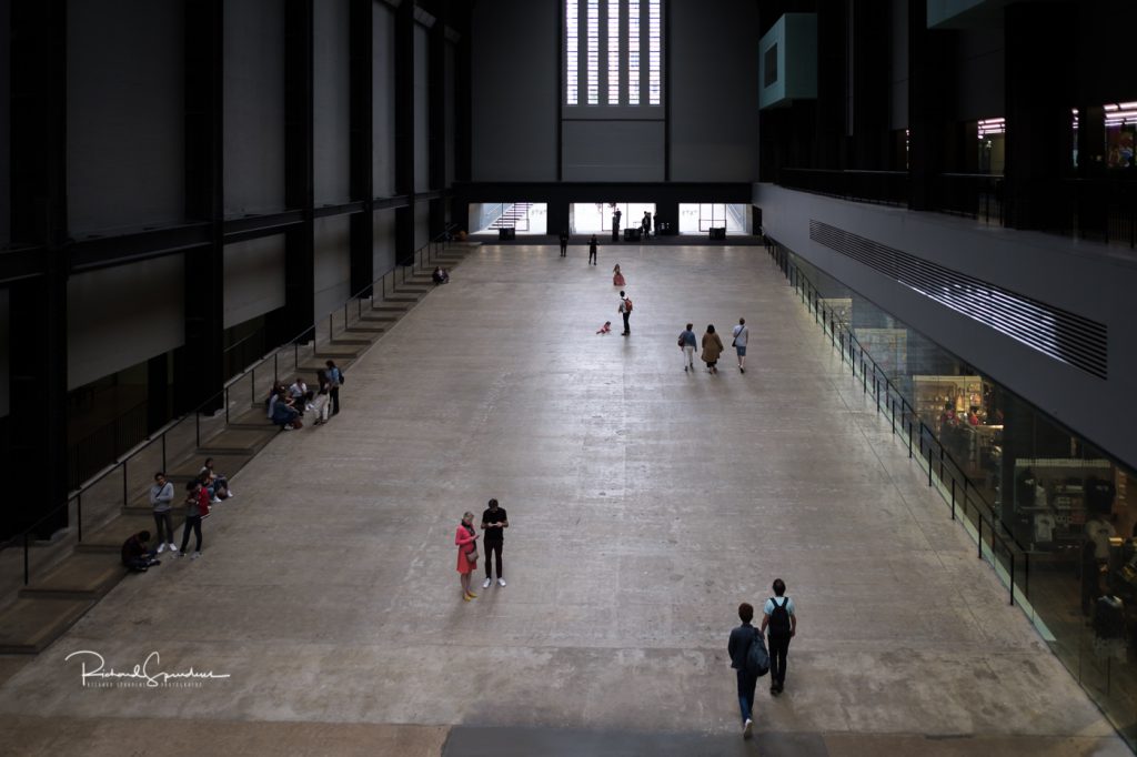 architecture photography - architecture photographer - the turbine hall at tate modern showing four small groups of people at various point on the vast floor