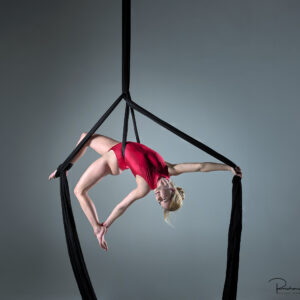 Aerial Arts photographer - Aerial silks photographer - Aerial Arts photography - Aerial silks photography -aerialist fanny m hanging in a dynamic pose in mid air using aerial silks
