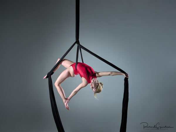 Aerial Arts photographer - Aerial silks photographer - Aerial Arts photography - Aerial silks photography -aerialist fanny m hanging in a dynamic pose in mid air using aerial silks