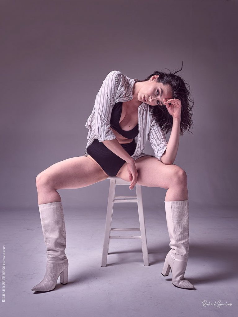 Fashion Photography - Fashion Photographer -model wearing white boots and striped shirt seated on a white stool