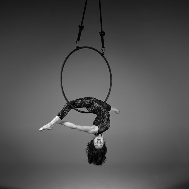 aerial arts photography - aerial arts photograher - monochrome image of aerial artist hang upside down in the splits the hoop