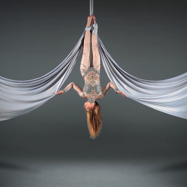 aerial arts photographer - aerial arts photography - aerial artist hanging with a feet anchor silks going out in arches