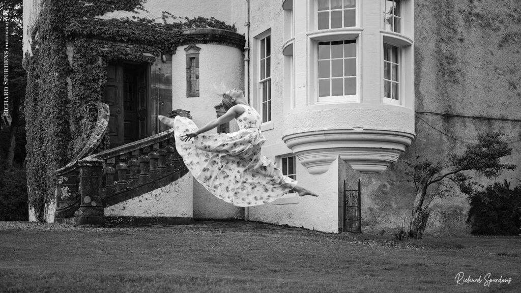 dance photographer - dance photography - outdoor dance moves with dancer leaping across the grass in front of the castle house