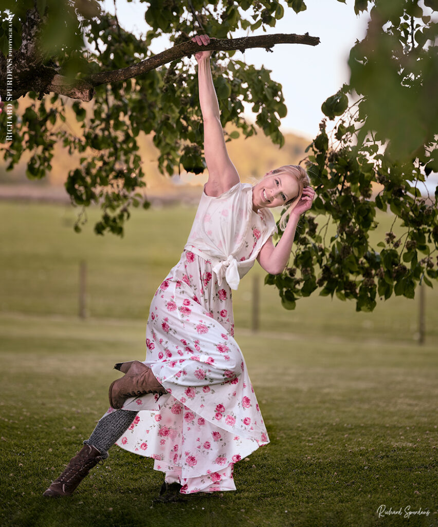 dance photographer - dance photography - outdoor dance moves with dancer in a white dress with red flowers patterns hanging from a tree branch