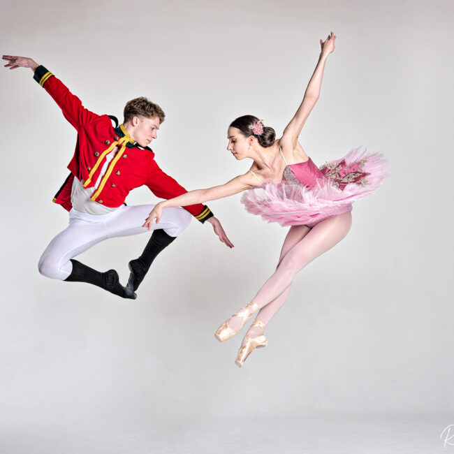 dance photographer - dance photography - duo pairing of male and female dancers leaping in sync