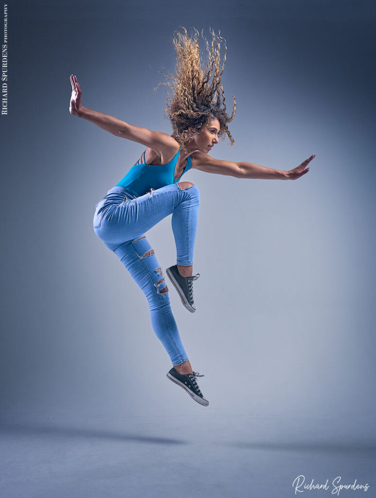 dance photographer - dance photography - dancer in mid leap across the stage arms out to the side