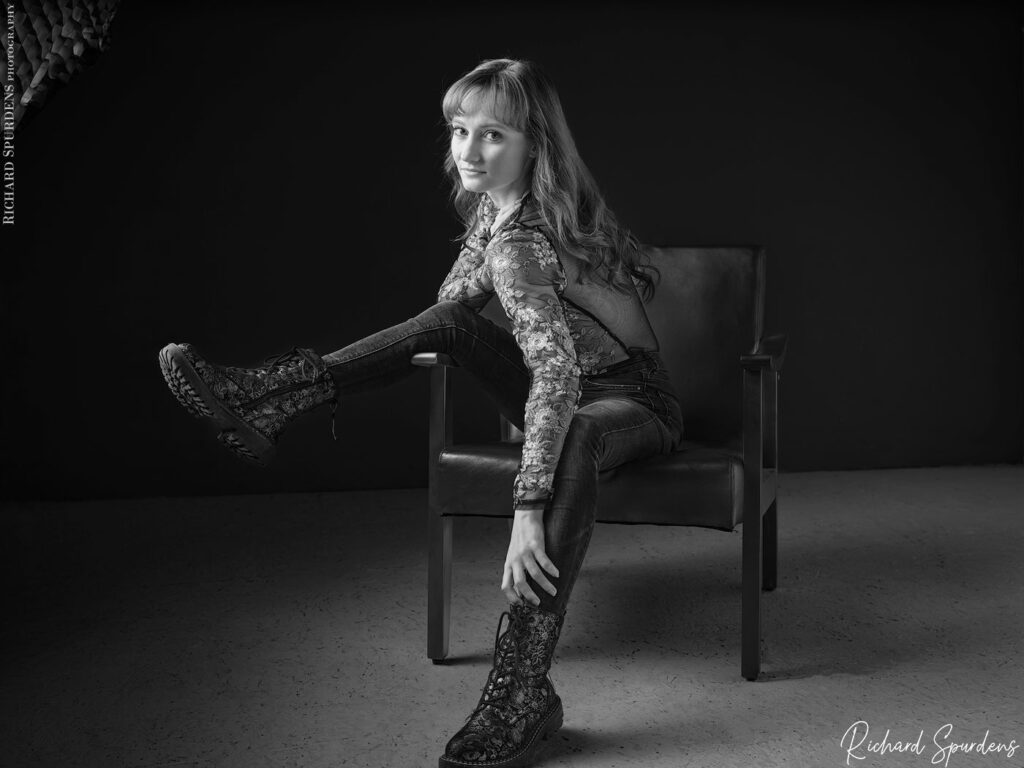 fashion photography fashion photographer - model seated on a chair showing off her doc martin boots