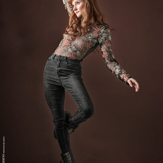 fashion photography- fashion photographer - model standing black jeans and a flower pattern top. Dancing to the beats