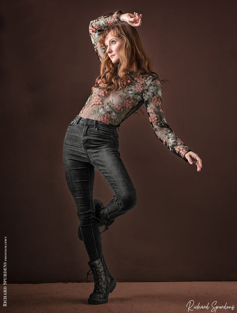 fashion photography- fashion photographer - model standing black jeans and a flower pattern top. Dancing to the beats