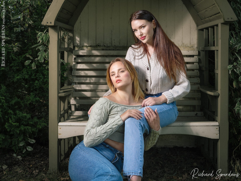 portrait photography - portrait photographer - head shot of the two model one seat on the bench and the other seated on the ground resting on the others legs