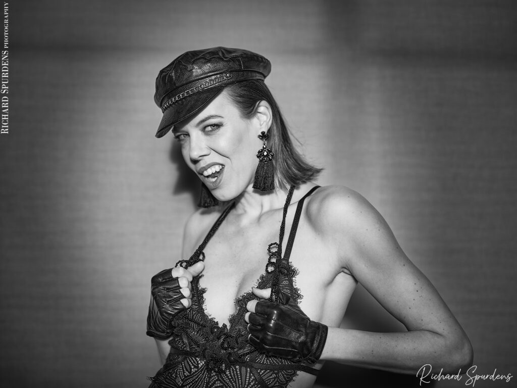 portrait photography - portrait photographer - natural light shot of model wearing black leather look cap and black fingerless gloves looking towards the camera