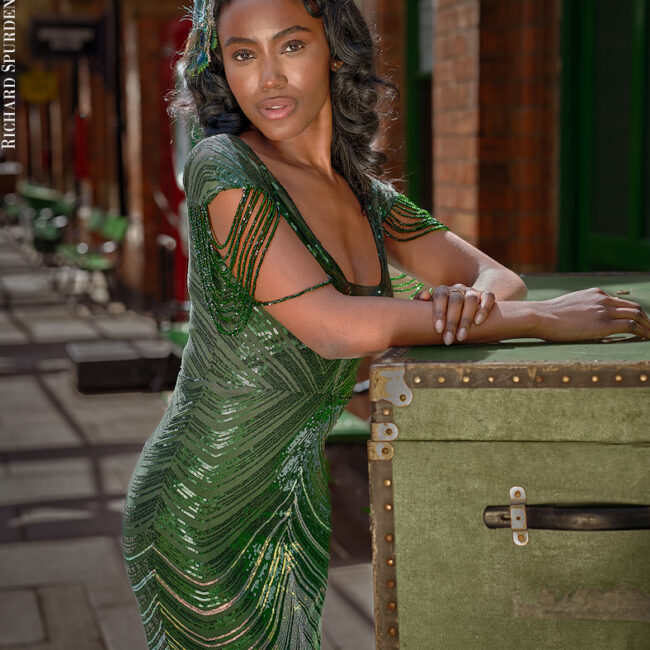 fashion photography fashion photographer- model shot on the station platform wearing a green sequin vintage dress
